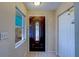 Interior foyer featuring a dark wooden front door with decorative glass and tile flooring at 8740 Forest Lake Dr, Port Richey, FL 34668