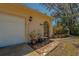 Covered and arched front entrance with beautiful tile, potted plants, and a stone retaining wall at 8740 Forest Lake Dr, Port Richey, FL 34668