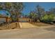 Single-story home featuring an attached two-car garage and long driveway with mature trees in the front yard at 8740 Forest Lake Dr, Port Richey, FL 34668