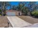 Charming single-story home with a wide driveway, two-car garage, and lush landscaping at 8740 Forest Lake Dr, Port Richey, FL 34668
