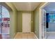 Hallway featuring tiled floors, an exterior door, and an arched opening to the kitchen area at 8740 Forest Lake Dr, Port Richey, FL 34668