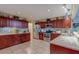 Well-lit kitchen featuring granite countertops, tile backsplash, and cherry wood cabinets at 8740 Forest Lake Dr, Port Richey, FL 34668