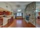 An open living room with hardwood floors and a stone fireplace at 8740 Forest Lake Dr, Port Richey, FL 34668