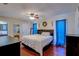 Bright main bedroom featuring hardwood floors, ceiling fan, ensuite bath, and neutral wall paint at 8740 Forest Lake Dr, Port Richey, FL 34668