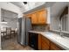 Kitchen featuring stainless steel appliances, wood cabinets, and a tiled backsplash at 891 Lantern Way # 13-103, Clearwater, FL 33765