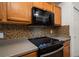 Kitchen with stainless appliances, mosaic tile backsplash, and gray countertops at 891 Lantern Way # 13-103, Clearwater, FL 33765