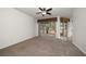 Spacious living area featuring carpeted floors, a ceiling fan, and sliding glass doors to the outside at 891 Lantern Way # 13-103, Clearwater, FL 33765