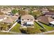 Overhead shot displays house with a manicured lawn, white fence, and outdoor living spaces at 9102 Tollison Loop, Land O Lakes, FL 34638