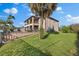 Lush backyard with a well-maintained lawn, palm trees, and a view of the home's exterior and patio at 9402 59Th N St, Pinellas Park, FL 33782