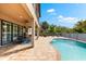 Exterior view of a covered patio with an outdoor dining area, lounge chairs, and a beautiful swimming pool at 9402 59Th N St, Pinellas Park, FL 33782