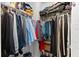 This is a walk-in closet with hanging clothes on rods and items stacked on shelves at 9402 59Th N St, Pinellas Park, FL 33782