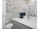 This bathroom offers gray cabinetry, artwork, and a glass-enclosed shower at 9817 Coneflower Ct, Land O Lakes, FL 34637