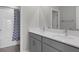 Well-lit bathroom with double vanity, quartz countertop, modern fixtures, and a shower-tub combo with a patterned curtain at 9817 Coneflower Ct, Land O Lakes, FL 34637
