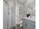 The main bathroom features a modern vanity with grey cabinets, shower with glass doors, and stylish decor at 9817 Coneflower Ct, Land O Lakes, FL 34637