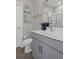 Bathroom featuring shaker cabinets, chrome hardware, flower art, and light countertops at 9817 Coneflower Ct, Land O Lakes, FL 34637