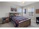 Comfortable bedroom with a rustic wood bed frame, book storage headboard, and two windows that provide ample natural light at 9817 Coneflower Ct, Land O Lakes, FL 34637