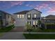 Charming two-story home featuring a balcony and a well-manicured lawn at dusk at 9817 Coneflower Ct, Land O Lakes, FL 34637