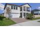 A beautiful two-story home featuring a balcony, well-manicured lawn, and brick driveway at 9817 Coneflower Ct, Land O Lakes, FL 34637