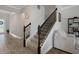 Elegant staircase with wood and iron railing leads to the upper level, with a view of the home's entry at 9817 Coneflower Ct, Land O Lakes, FL 34637