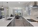 Stylish kitchen with a white countertop island and gray cabinets, open to the dining area with backyard views at 9817 Coneflower Ct, Land O Lakes, FL 34637