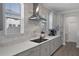 Updated kitchen featuring marble backsplash, stainless hood, and modern cooktop at 9817 Coneflower Ct, Land O Lakes, FL 34637