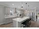 Modern kitchen boasts a large island, stainless steel appliances, pendant lighting, and gray cabinets at 9817 Coneflower Ct, Land O Lakes, FL 34637