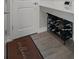 Mudroom offers tile flooring, door, storage bench with coat hooks, and a shoe rack to organize belongings at 9817 Coneflower Ct, Land O Lakes, FL 34637