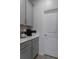 Pantry featuring gray cabinets, white countertops, shelving units and a coffee bar at 9817 Coneflower Ct, Land O Lakes, FL 34637