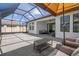 Screened patio with seating area, ceiling fan, and coffee table, creating a relaxing outdoor space at 9817 Coneflower Ct, Land O Lakes, FL 34637