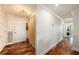 A long hallway with beautiful hardwood floors and decorative wainscoting leading to a room with a view at 100 Bluff View Dr # 614A, Belleair Bluffs, FL 33770