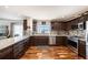 Modern kitchen with dark wood cabinets, stainless steel appliances, and granite countertops at 100 Bluff View Dr # 614A, Belleair Bluffs, FL 33770