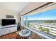 Bright living room space with beautiful hardwood floors, a large window offering waterfront view and comfortable furniture at 100 Bluff View Dr # 614A, Belleair Bluffs, FL 33770