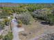 Expansive aerial view showcases a residence with a detached garage, long driveway, and lush landscaping at 10100 Grove Dr, Port Richey, FL 34668