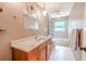 Bathroom features a spacious vanity, ceiling fan, a decorative light fixture, and a shower/tub combination at 10100 Grove Dr, Port Richey, FL 34668