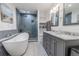 Modern bathroom features a soaking tub, glass shower with a tiled accent wall, double sink vanity with granite counters at 10100 Grove Dr, Port Richey, FL 34668