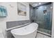 Contemporary bathroom featuring a stylish soaking tub and a modern glass shower with tiled accents at 10100 Grove Dr, Port Richey, FL 34668