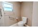 Neutral-toned bathroom with accessible features including grab bars and easy-access toilet at 10100 Grove Dr, Port Richey, FL 34668