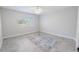Bright bedroom with a neutral palette features a window view and a decorative area rug at 10100 Grove Dr, Port Richey, FL 34668