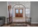 Grand foyer featuring decorative archway, tile flooring, and stylish double doors at 10100 Grove Dr, Port Richey, FL 34668