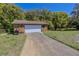 Detached two-car garage with stone facade and driveway, perfect for vehicle storage and workshop space at 10100 Grove Dr, Port Richey, FL 34668