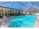 Backyard pool with screened-in enclosure, stone accents, and outdoor seating area at 10100 Grove Dr, Port Richey, FL 34668