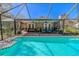 Relaxing screened-in pool area with stone patio, ceiling fans, and comfortable seating for enjoying outdoor living at 10100 Grove Dr, Port Richey, FL 34668