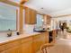 Traditional kitchen with natural wood cabinets, light countertops, black appliances and a view to the living room at 10402 N Boulevard, Tampa, FL 33612