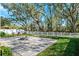 Backyard patio featuring pavers and a firepit, surrounded by a white fence and mature trees at 13001 Satin Lily Dr, Riverview, FL 33579