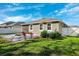 The backyard has lush green grass, bushes, a fire pit area, and a white vinyl fence at 13001 Satin Lily Dr, Riverview, FL 33579