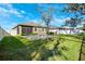View of the backyard with green grass, a patio area with a fire pit and a screen-enclosed lanai at 13001 Satin Lily Dr, Riverview, FL 33579