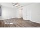 Spacious bedroom featuring wood-look floors, white walls, ceiling fan and two white doors at 13001 Satin Lily Dr, Riverview, FL 33579
