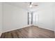 This bright bedroom features wood-look floors, white walls, a ceiling fan, and closet with sliding doors at 13001 Satin Lily Dr, Riverview, FL 33579