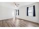 Bright bedroom with wood-look flooring, white walls, and natural light from windows with blue curtains at 13001 Satin Lily Dr, Riverview, FL 33579
