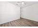 Empty bedroom featuring wood-look floors, white walls, a ceiling fan, and a white door at 13001 Satin Lily Dr, Riverview, FL 33579